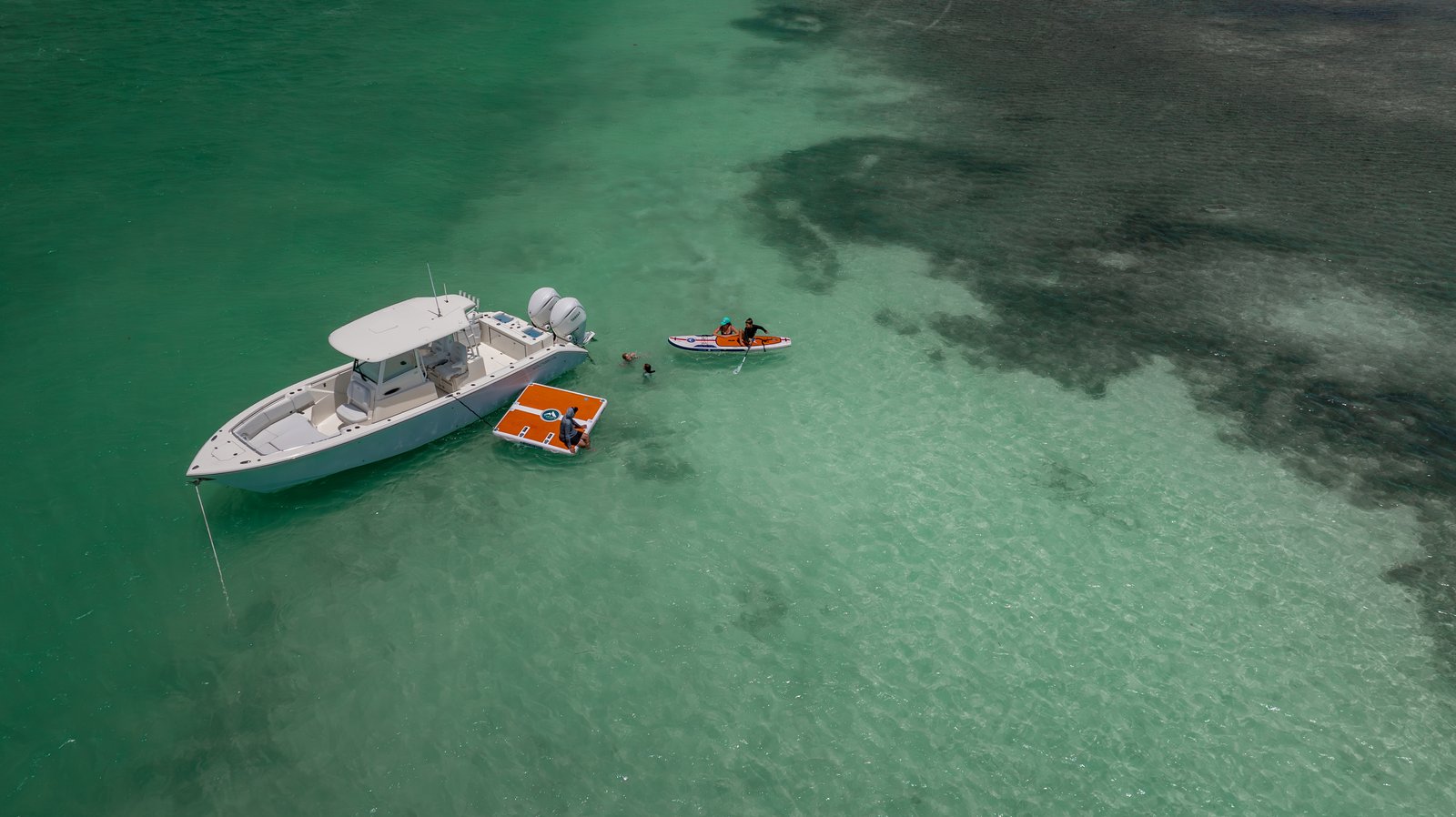Beauty drone shot of white Cobia 320 CC offshore center console running over blue ocean water
