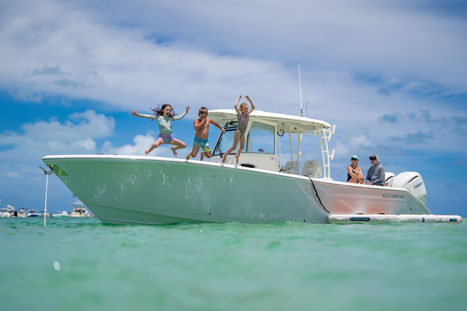 Kids jumping off Cobia 320CC
