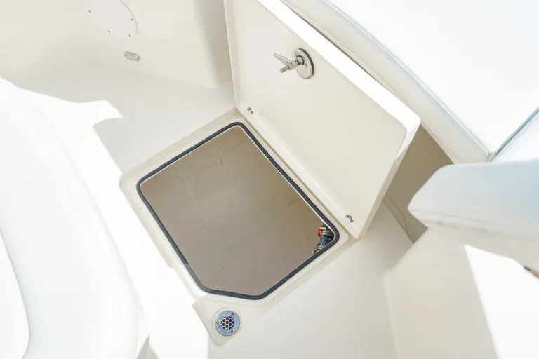 Cobia 320 CC bow underfloor storage compartment open showing lockable hatch access to below-deck storage under bow seating