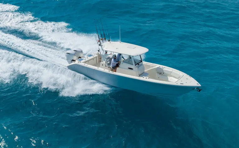 Drone beauty shot of Cobia 320 CC offshore fishing boat running over blue open water
