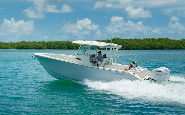 Cobia 320 CC starboard-bow running shot with family near Florida Keys islands and Yamaha outboard