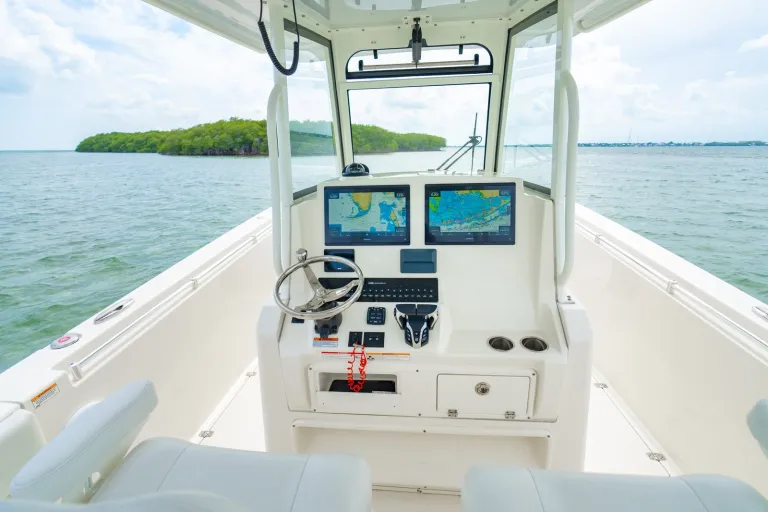 Cobia 320 CC helm dashboard featuring dual Garmin GPSMAP chart plotters, stainless GEM steering wheel, and Yamaha Helm Master engine controls