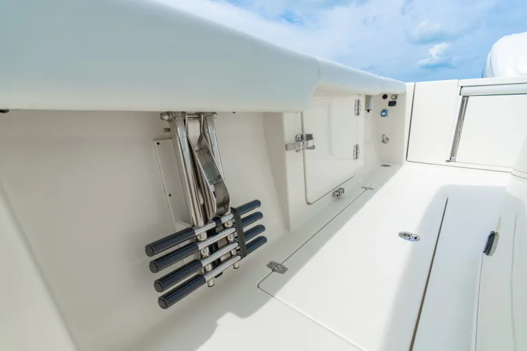 Cobia 320 CC under-gunnel stainless steel rod holder rack with multiple fishing rod slots mounted beneath the gunnel rail